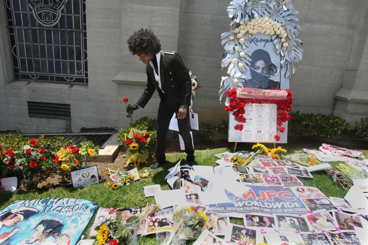 A man identified only as Jovan adjusts a flower at a memorial to Michael Jackson as fans gather at the Great Mausoleum at Forest Lawn Memorial Park on June 25 in Glendale.