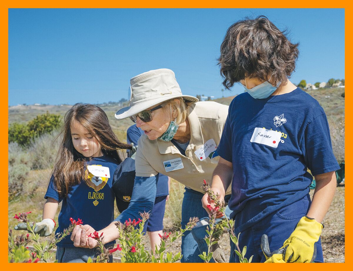 The best summit-worthy snacks to help you refuel on your hike 13 A woman holds a red flower for two children to see.