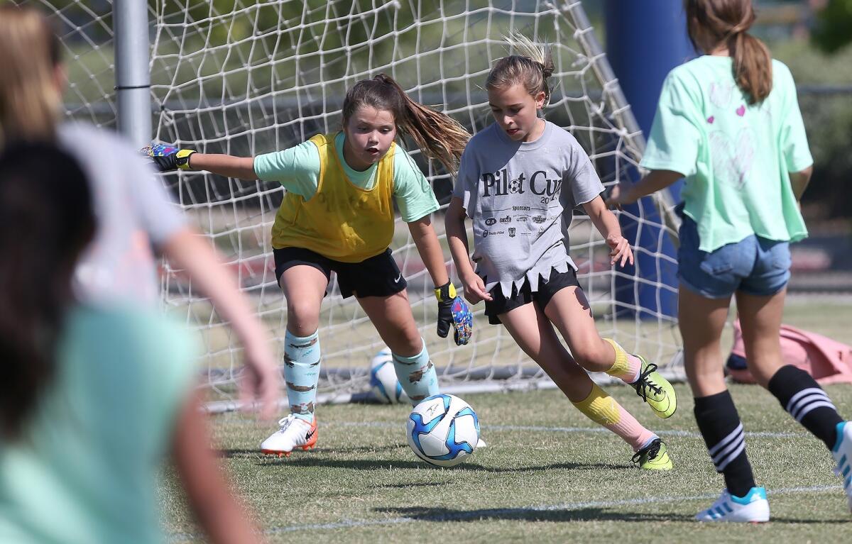 Newport Beach Our Lady Queen of Angels' Liliana Ure tries to shoot as Newport Beach Eastbluff goalkeeper Kate Nourse defends in the girls' fifth- and sixth-grade Silver Division pool-play match at the Daily Pilot Cup in Costa Mesa on Wednesday.