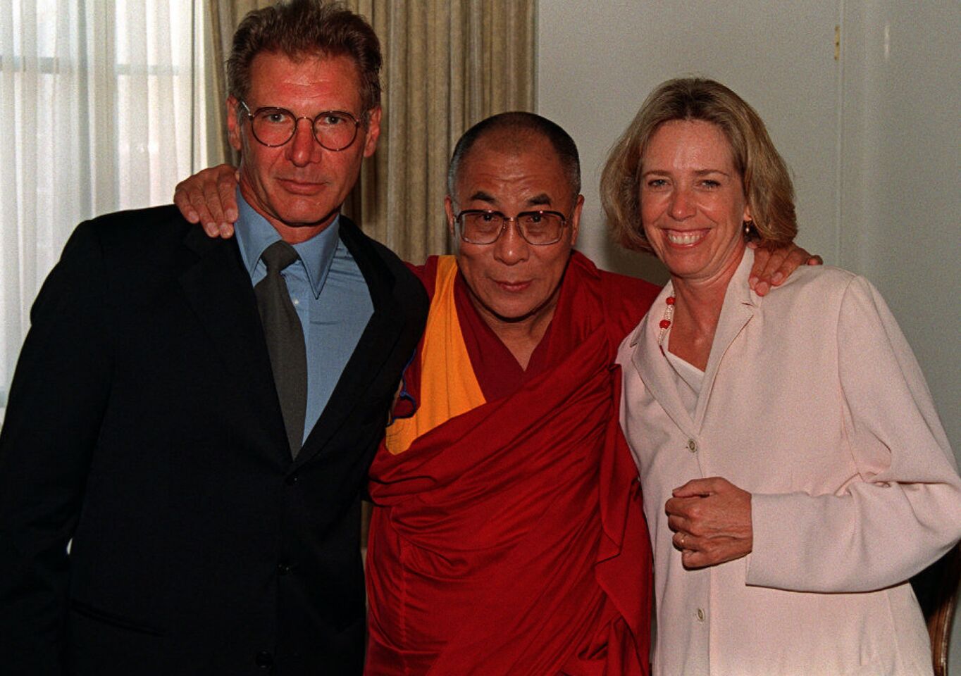 Actor Harrison Ford, left, and then-wife Melissa Mathison pose with the Dalai Lama of Tibet during a star–studded dinner in Beverly Hills in August 1996.