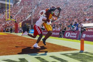 LOS ANGELES, CA - SEPTEMBER 28, 2024: USC Trojans wide receiver Ja'Kobi Lane (8) scores on a 6-yard pass against Wisconsin Badgers cornerback Xavier Lucas (6) touchdown on a at the LA Coliseum on September 28, 2024 in Los Angeles, California. (Gina Ferazzi / Los Angeles Times)