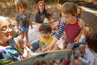 SOUTH PASADENA-CA-JULY 16, 2024: Fabienne Hadorn, co-founder of Arroyo Nature School, an outdoor-based program for preschool-aged kids, left, reads to the children in South Pasadena on July 16, 2024. (Christina House / Los Angeles Times)