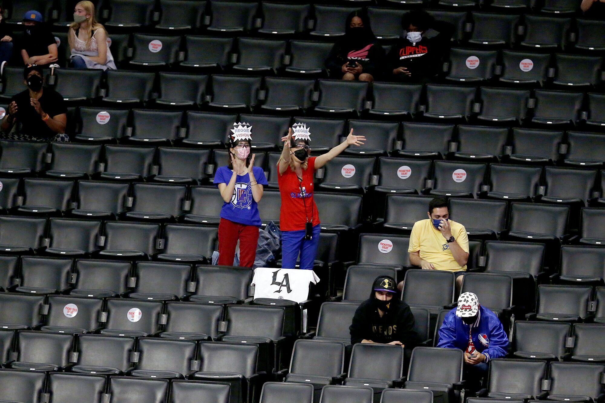 Fans of Clippers guard Reggie Jackson cheer from their socially distanced, designated seats on April 18.