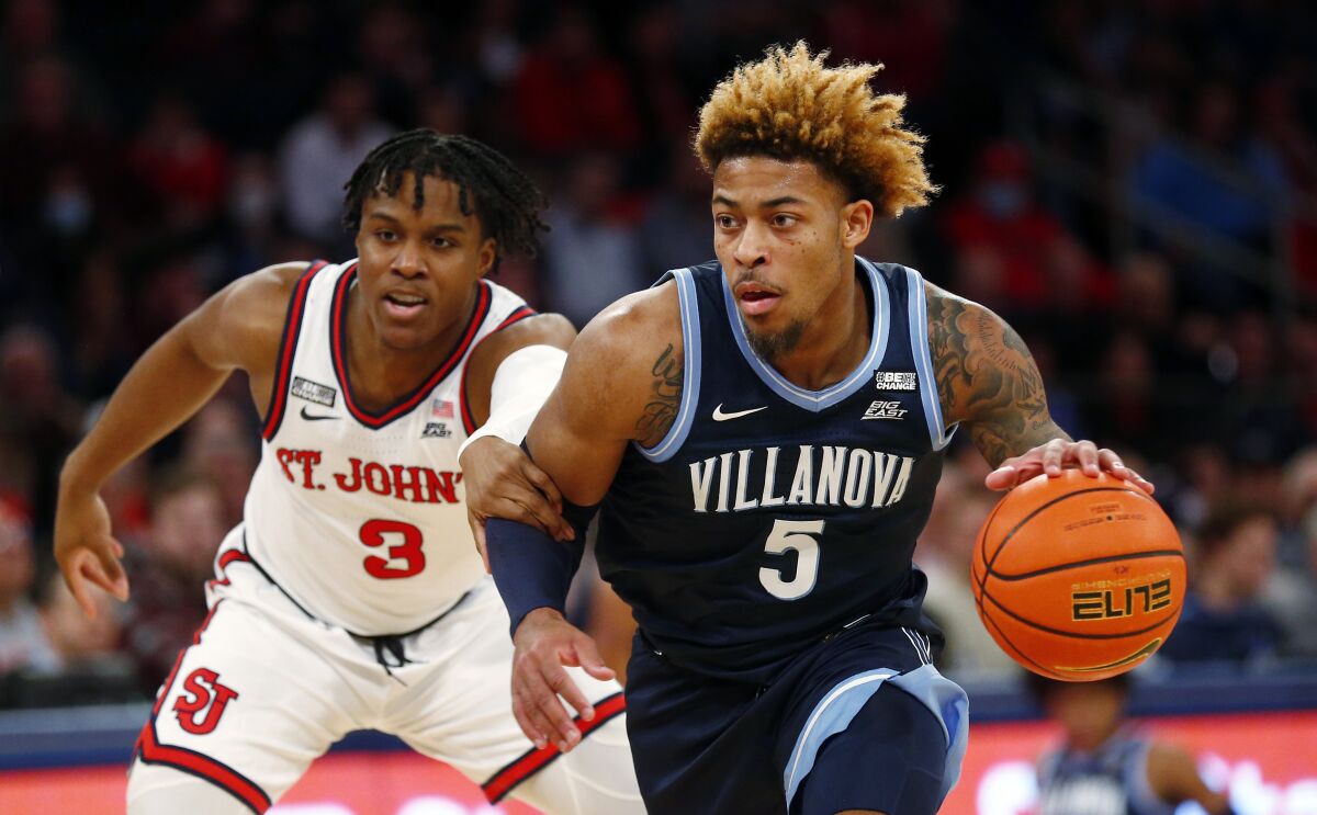 Villanova guard Justin Moore (5) dribbles to the basket while past St. John's guard Stef Smith (3) during the first half of an NCAA college basketball game Tuesday, Feb. 8, 2022, in New York. (AP Photo/John Munson)