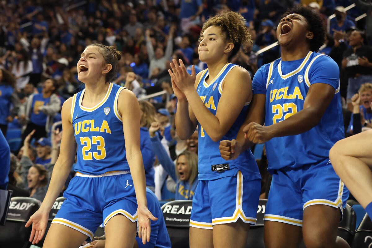 UCLA freshmen, from left, Gabriela Jaquez, Kiki Rice and Christeen Iwuala cheer on the bench.