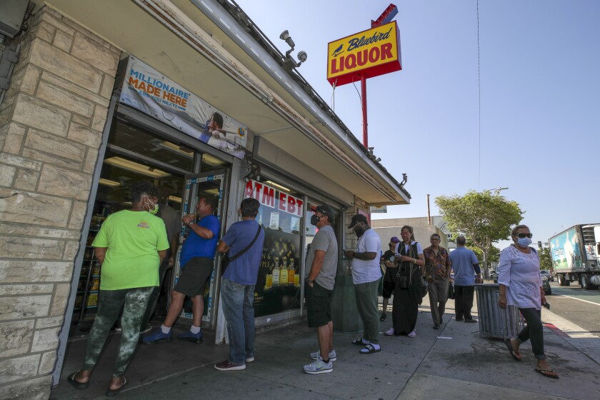 People stand in line to buy tickets for the Mega Millions lottery.
