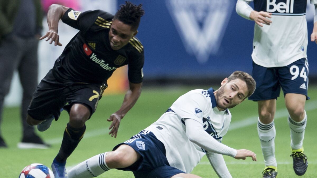 Vancouver Whitecaps midfielder Ion Erice, lower right, fights for control of the ball with LAFC forward Latif Blessing (7) during the first half.