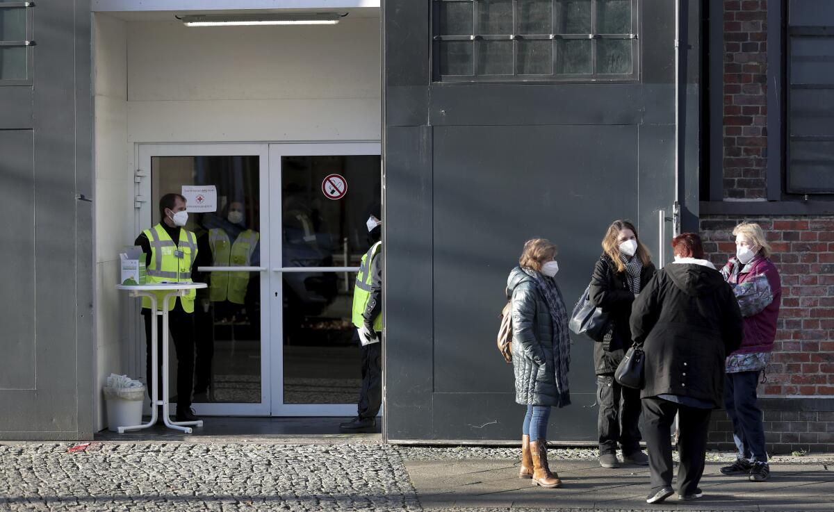People gather outside a COVID-19 vaccination center in Berlin on Wednesday.