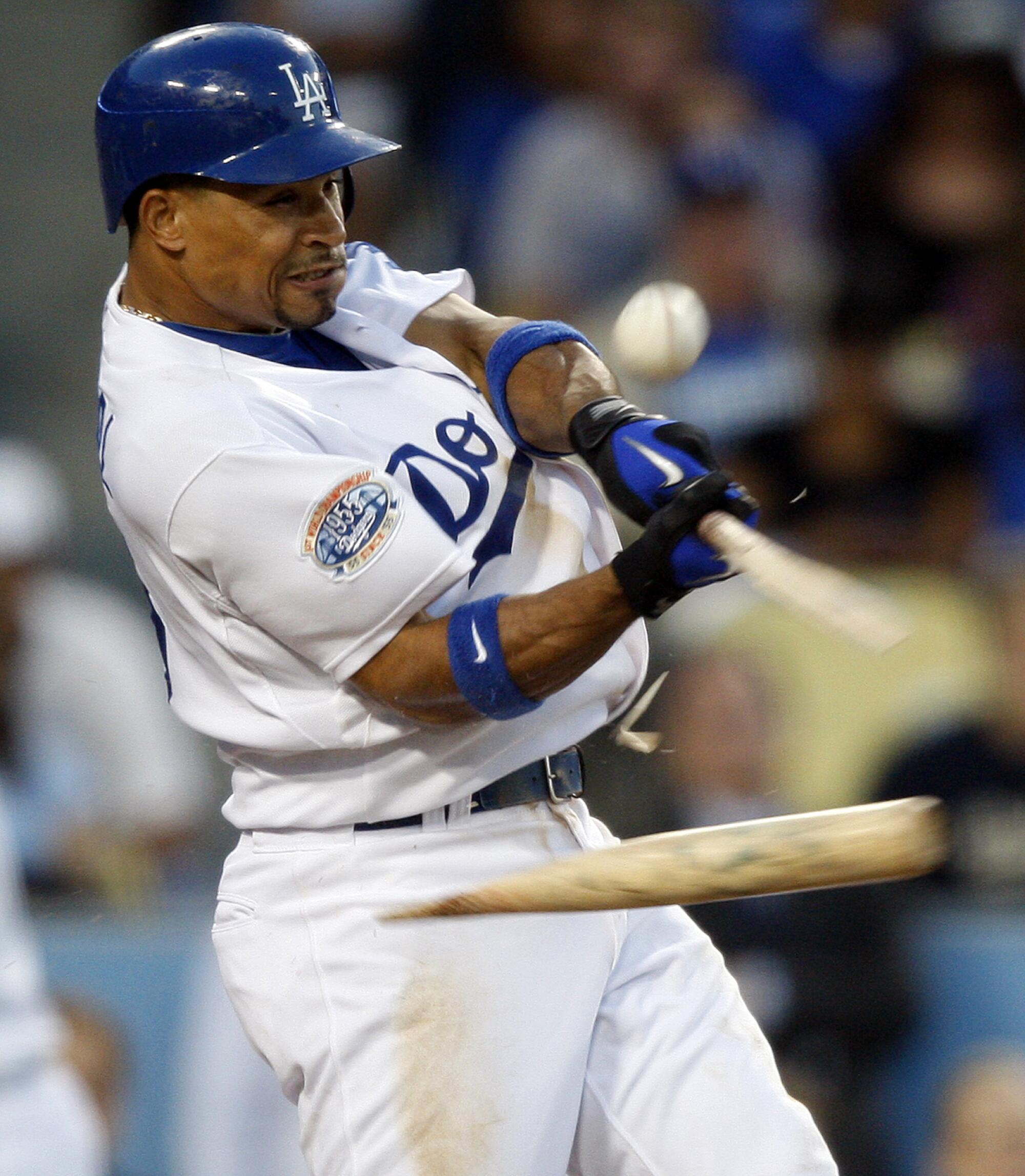 A Dodgers player breaks a bat on a pitch