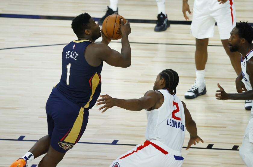 New Orleans Pelicans' Zion Williamson, left, drives to the basket against Los Angeles Clippers' Kawhi Leonard during an NBA basketball game Saturday, Aug. 1, 2020, in Lake Buena Vista, Fla. (Kevin C. Cox/Pool Photo via AP)