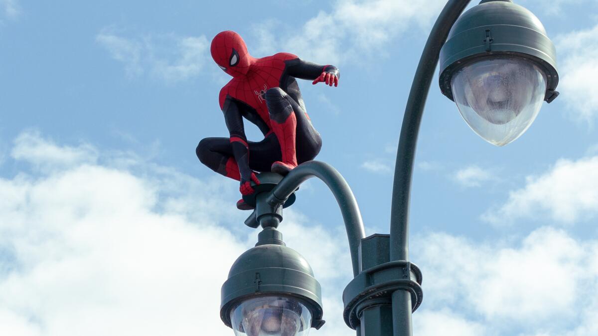 Spider-Man balancing on top of a street lamp