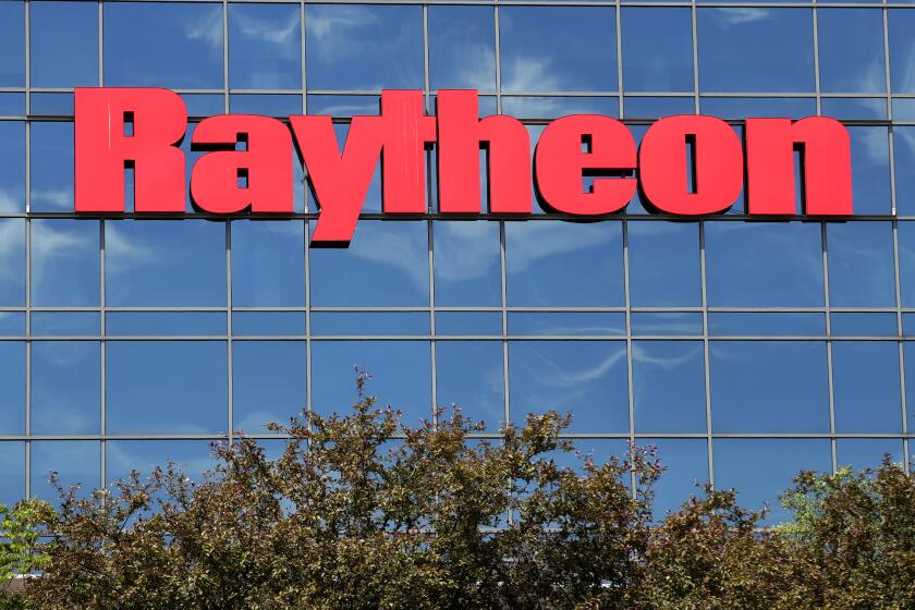 FILE - The sky is reflected on the facade of Raytheon's Integrated Defense Systems facility, Monday, June 10, 2019, in Woburn, Mass. (AP Photo/Elise Amendola, File)