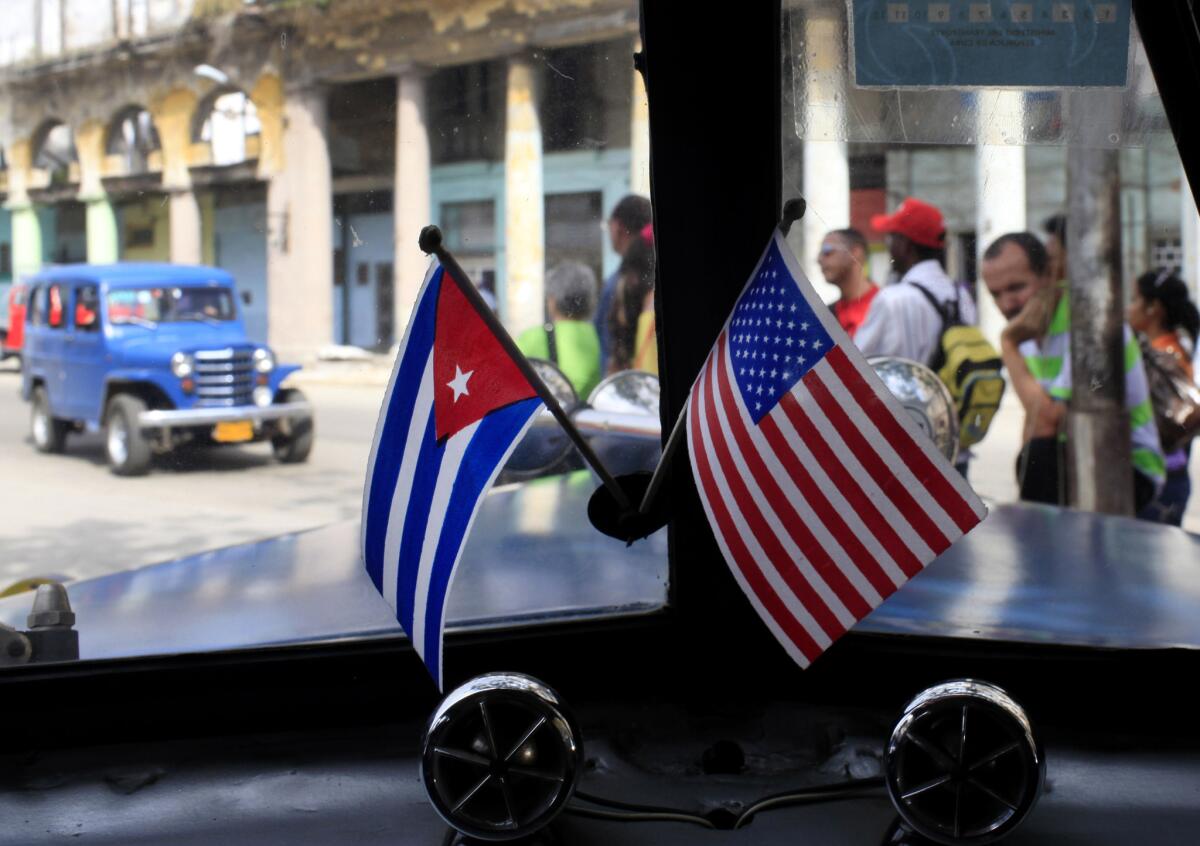 Flags of Cuba and the U.S. are displayed on the dashboard of a car in Havana in March 2013. The Obama administration is easing the embargo against Cuba.