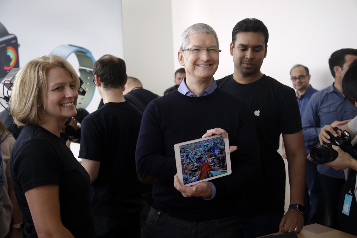 Apple CEO Tim Cook shows off a new iPad during an event at Apple headquarters.