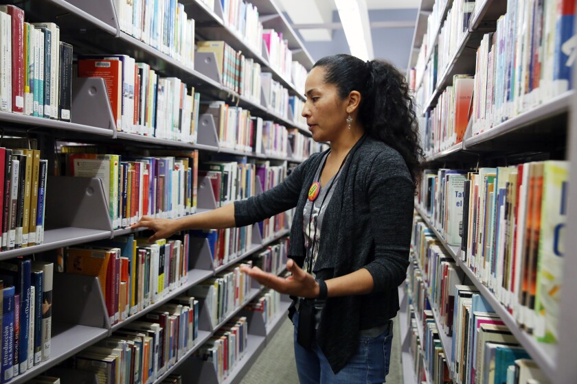 Senior Librarian Ana Campos looks for a book at the Central Branch of the Los Angeles Public Library in 2019.