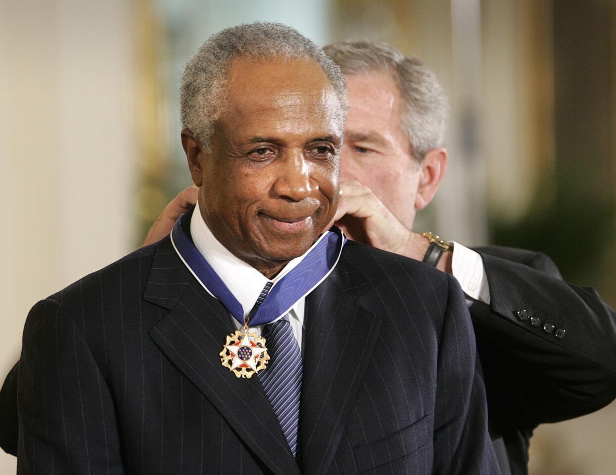 President George W. Bush awards baseball legend Frank Robinson the Presidential Medal of Freedom in the East Room of the White House in Washington on Nov. 9, 2005.