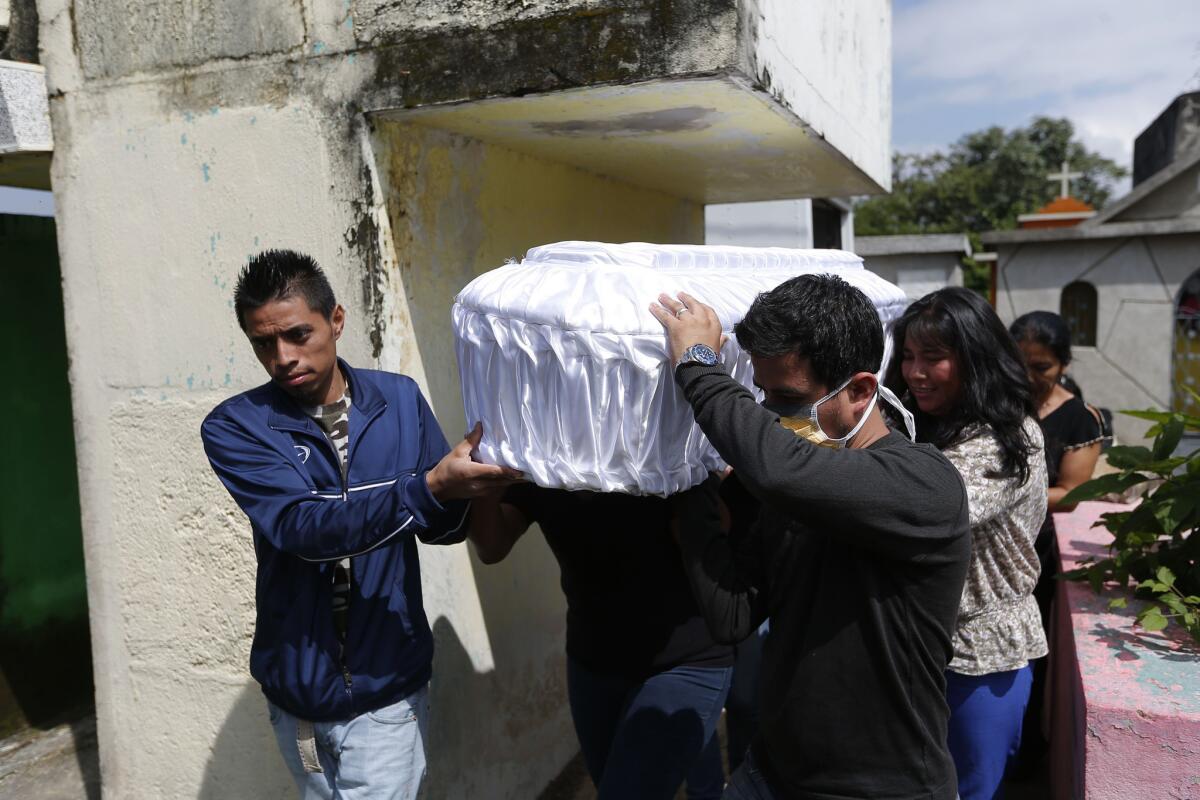 Personas transportan una urna durante el sepelio de cinco de las víctimas del deslave en Santa Catarina Pinulaen las afueras de Ciudad de Guatemala, el martes 6 de octubre de 2015.