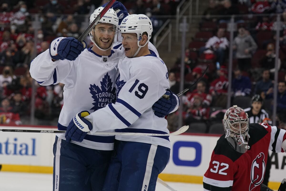 Toronto Maple Leafs' Pierre Engvall, left, celebrates his goal with Jason Spezza as New Jersey Devils goaltender Jon Gillies, right, looks on during the second period of the NHL hockey game in Newark, N.J., Tuesday, Feb. 1, 2022. (AP Photo/Seth Wenig)