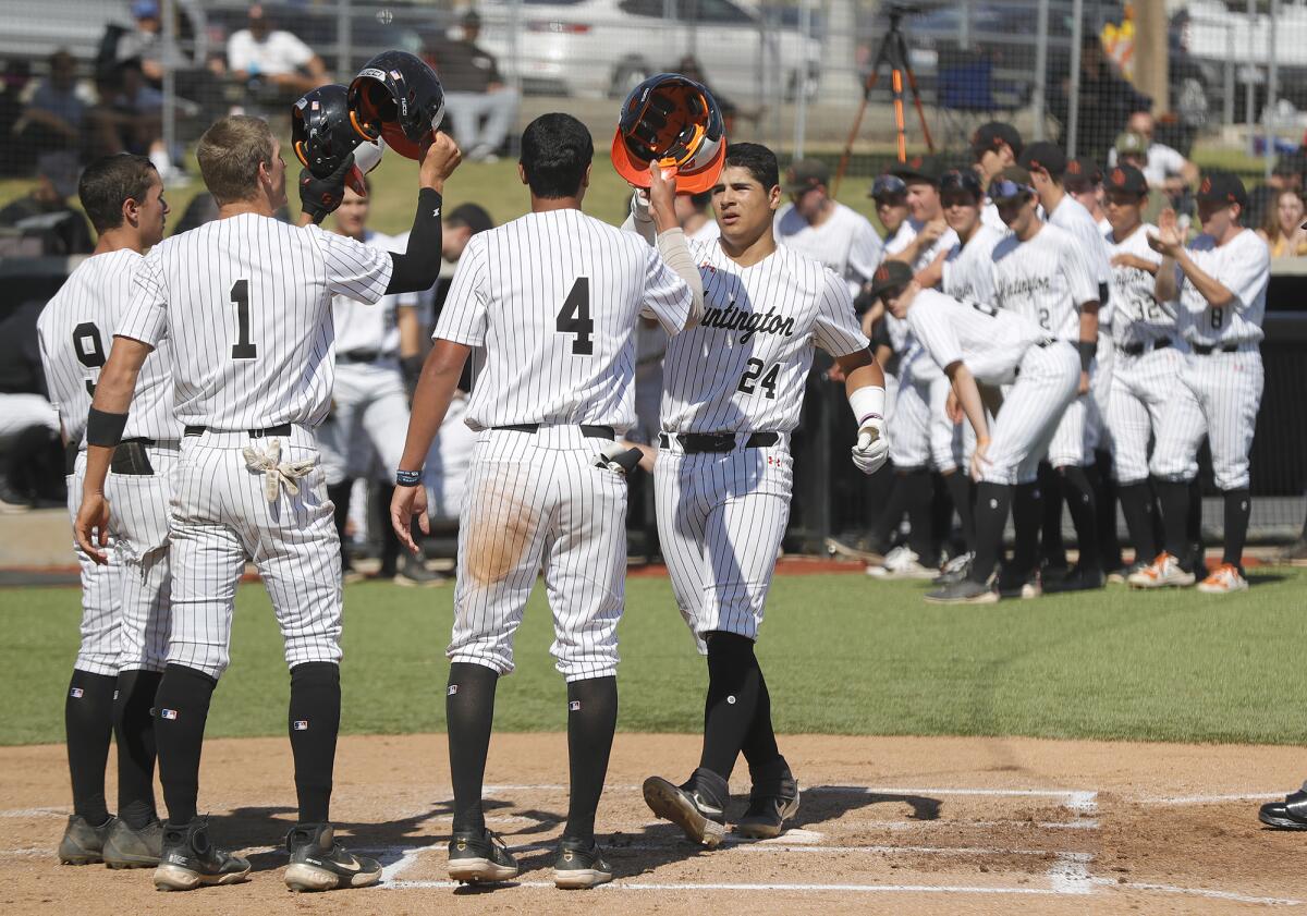 Ralph Velasquez (24) high-fives teammates Aiden Espinoza (9), Dean Carpentier (1), and Linkin Garcia (4).