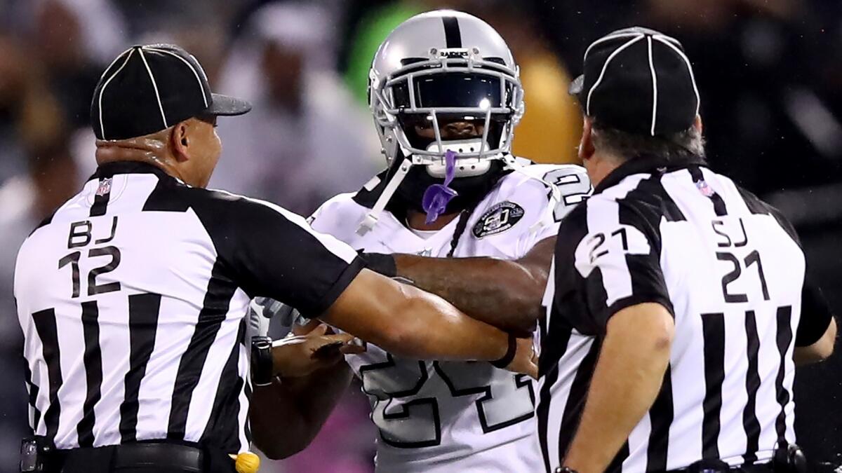 Raiders running back Marshawn Lynch is restrained by officials after coming off the bench and shoving a referee during an altercation with the Chiefs last week.