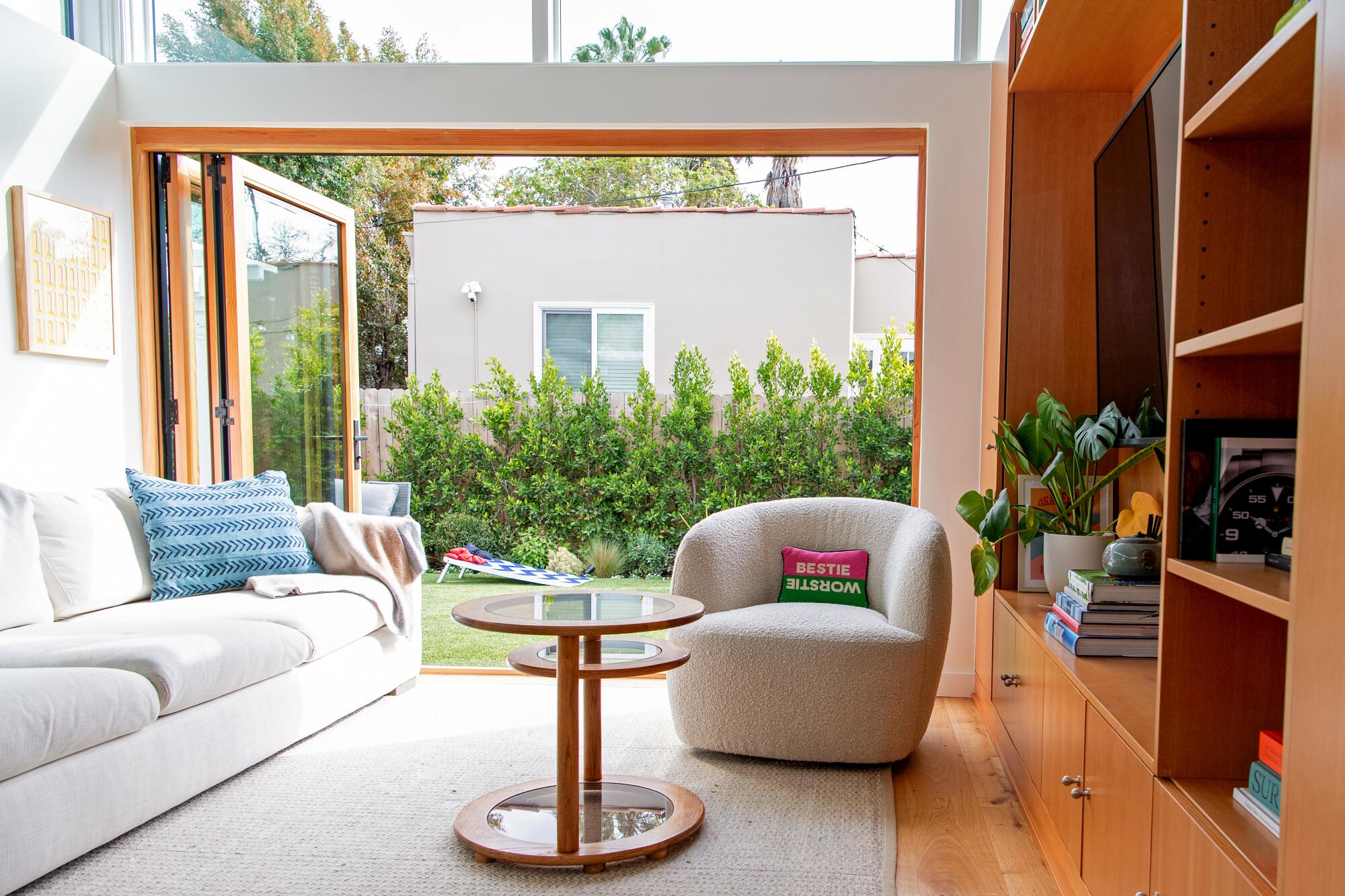 A living room with a bifold glass door opening to a yard.