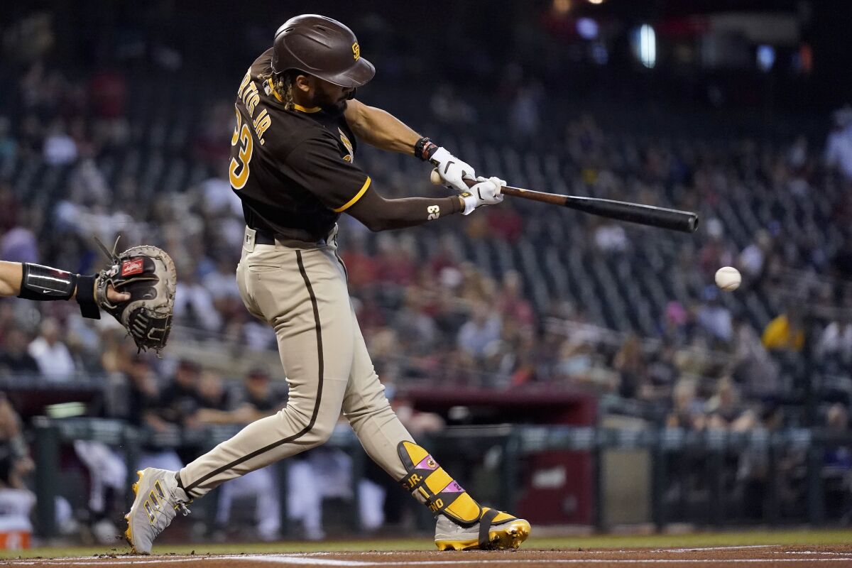 San Diego Padres' Fernando Tatis Jr. connects for a double against the Arizona Diamondbacks during the first inning of a baseball game, Sunday, Aug. 15, 2021, in Phoenix. (AP Photo/Ross D. Franklin)