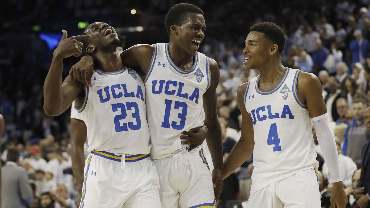 UCLA guard Kris Wilkes (13) celebrates after scoring the go-ahead basket with teammates Prince Ali (23) and Jaylen Hands (4) against Notre Dame.