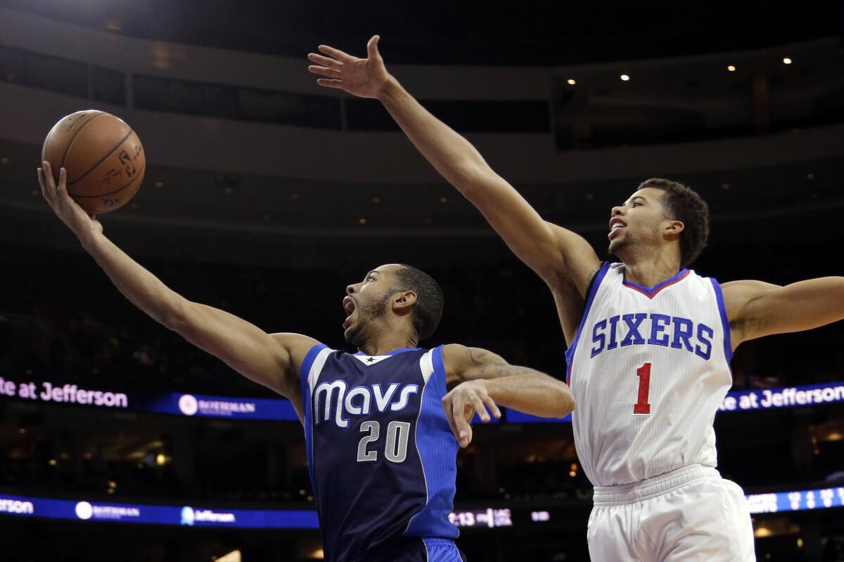 Dallas' Devin Harris goes up for a shot past Philadelphia's Michael Carter-Williams on Saturday.