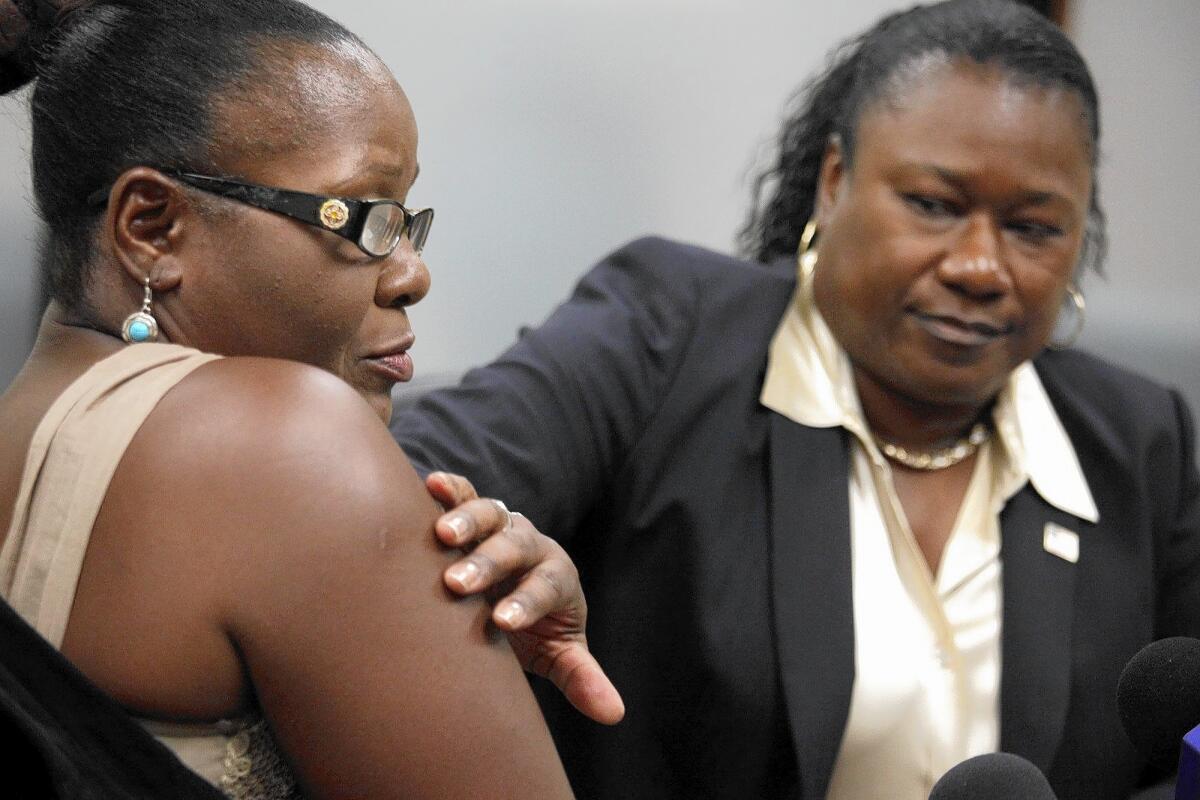 Lawyer Caree Harper, right, runs her hand over a lump that remains on client Marlene Pinnock's arm seven weeks after Pinnock was repeatedly punched by CHP Officer Daniel Andrew.