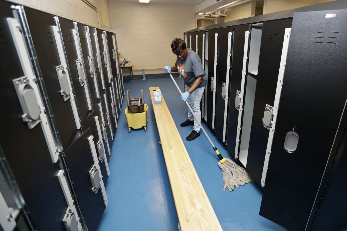 Custodian Joan Garner washes the floor in the pool locker room at Orange High School in Pepper Pike, Ohio.