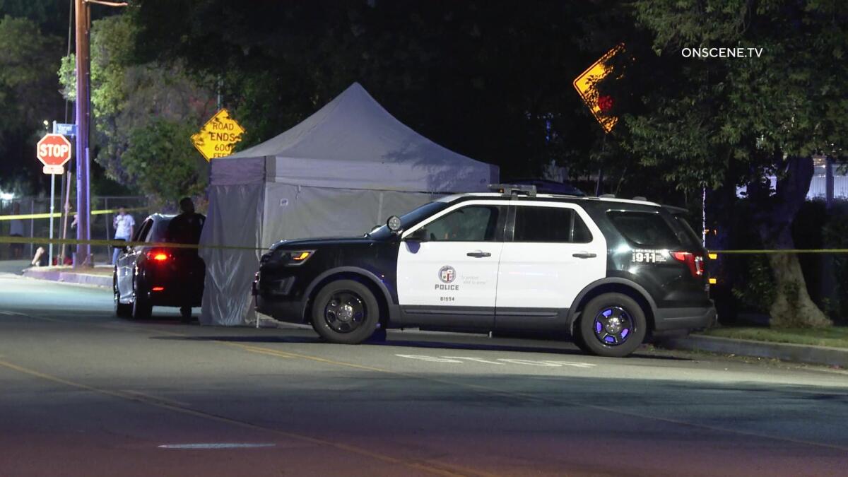 A police vehicle is next to a tent on the street