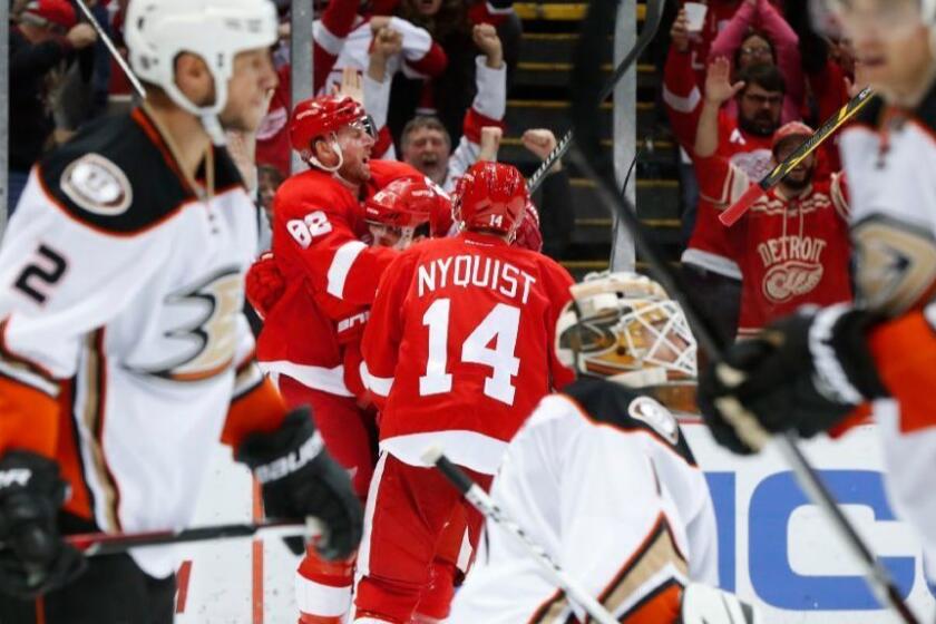 Red Wings defenseman Xavier Ouellet celebrates a goal against the Ducks with his teammates Thomas Vanek (62) and Gustav Nyquist (14) during the second period of a game on Dec. 17.