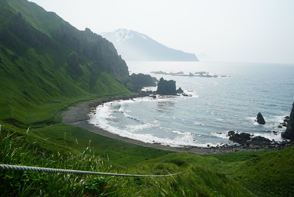 This July 7, 2021 photo shows a rope mounted cliffside at Horseshoe Bay that assists climbers to descend to the shore and nearby hot springs below on Adak Island, Alaska. (Nicole Evatt via AP)