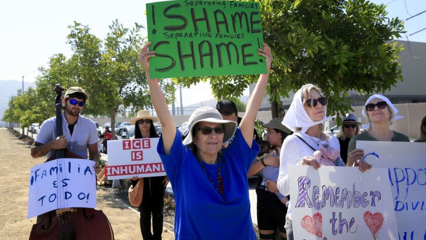 Protestors held signs during their rally held near the driveway entrance to the Otay Mesa Detention Center on Sunday morning.