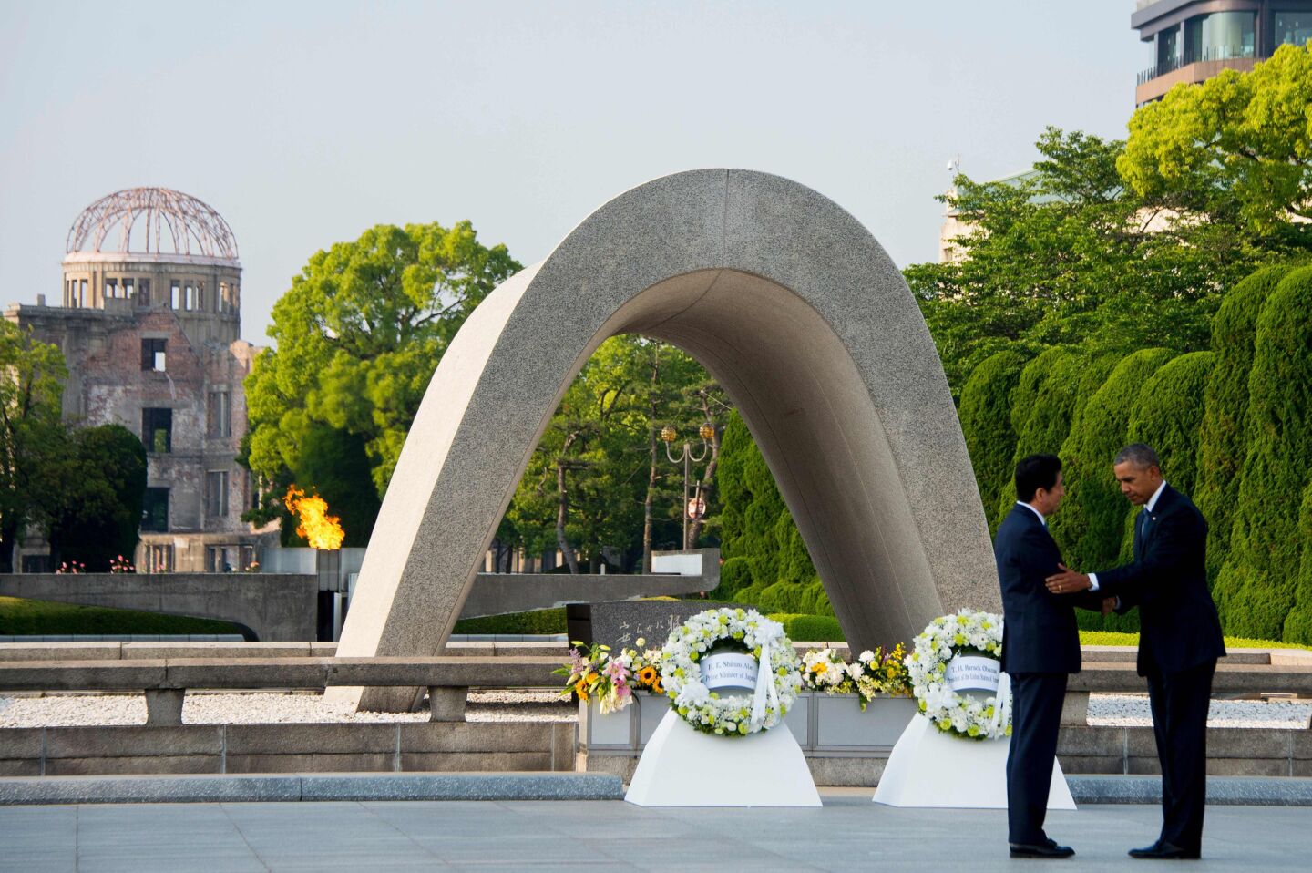 President Obama and Japanese Prime Minister Shinzo Abe shake hands after laying wreaths at Hiroshima Peace Memorial Park.