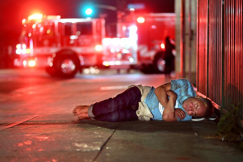 LOS ANGELES, CALIFORNIA AUGUST 30, 2019-A homeless man sleeps outside L.A. City Fire Department Station 9, the busiest station in the country. (Wally Skalij/Los Angeles Times)