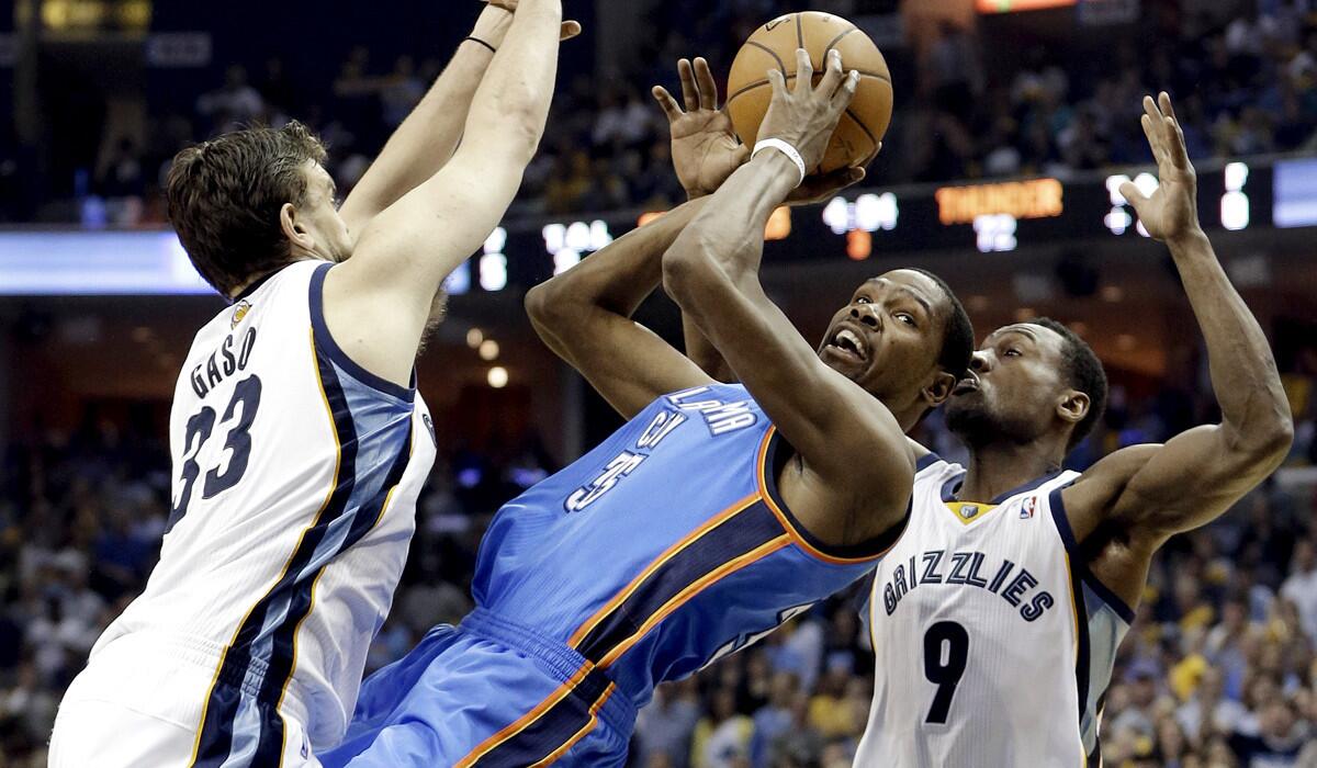 Thunder forward Kevin Durant tries to get off a shot as he falls backward between Grizzlies center Marc Gasol and guard Tony Allen (9) in the second half of a playoff game on Thursday night in Memphis.