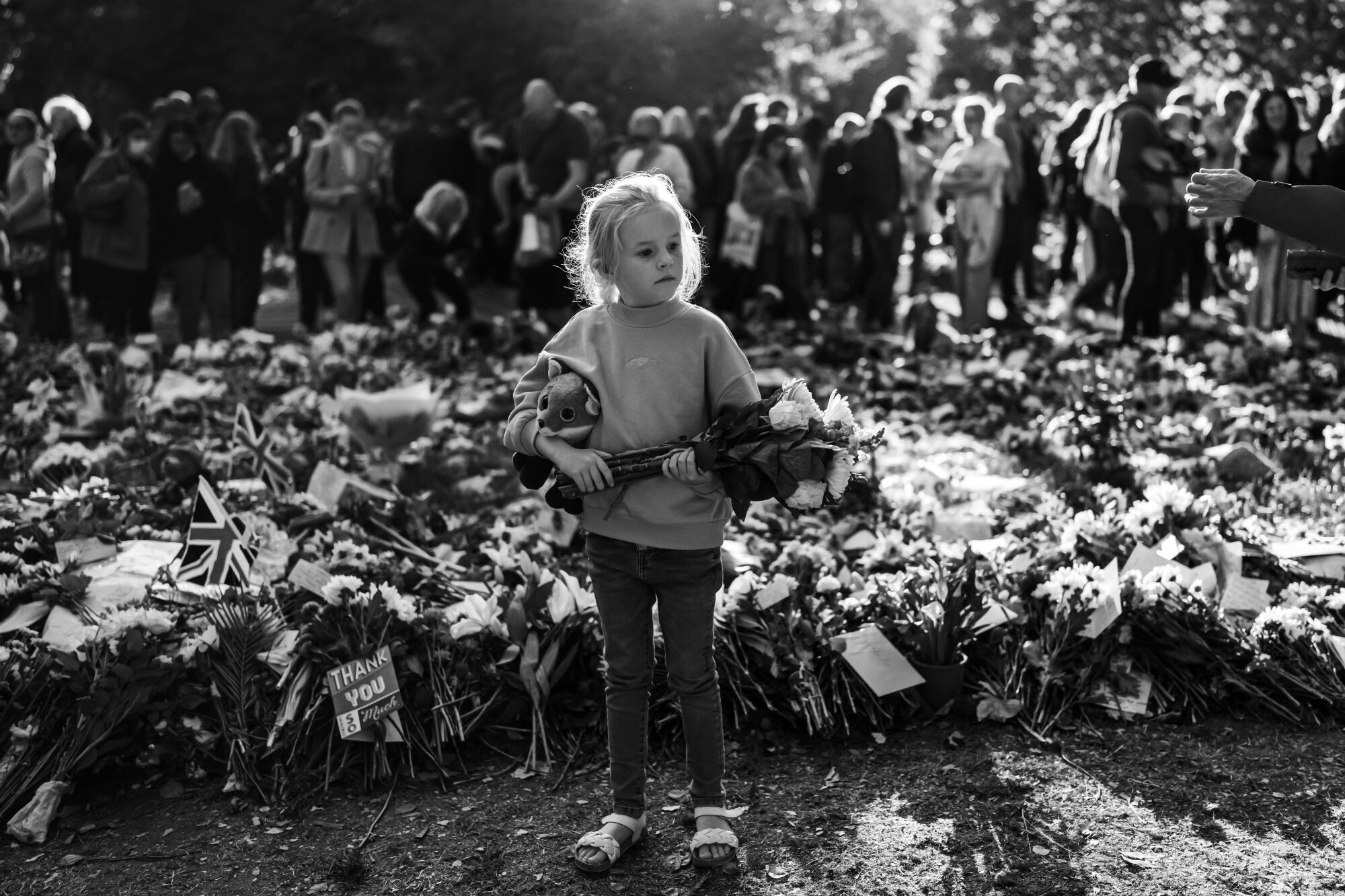 A young girl carry's flowers and a stuffed animal in Green Park