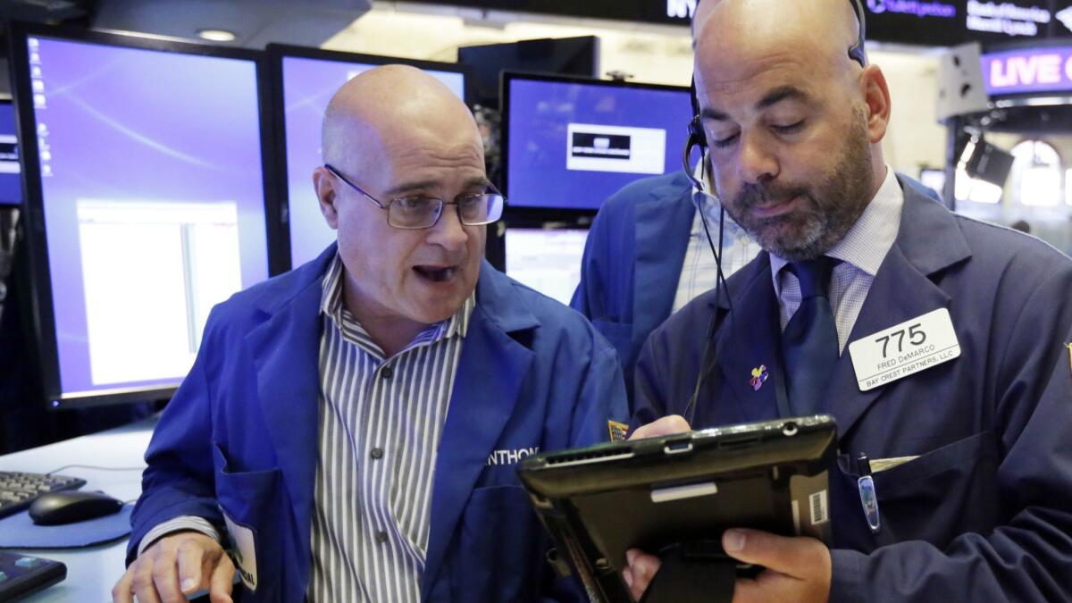 Specialist Anthony Confusione, left, and trader Fred DeMarco work on the floor of the New York Stock Exchange,