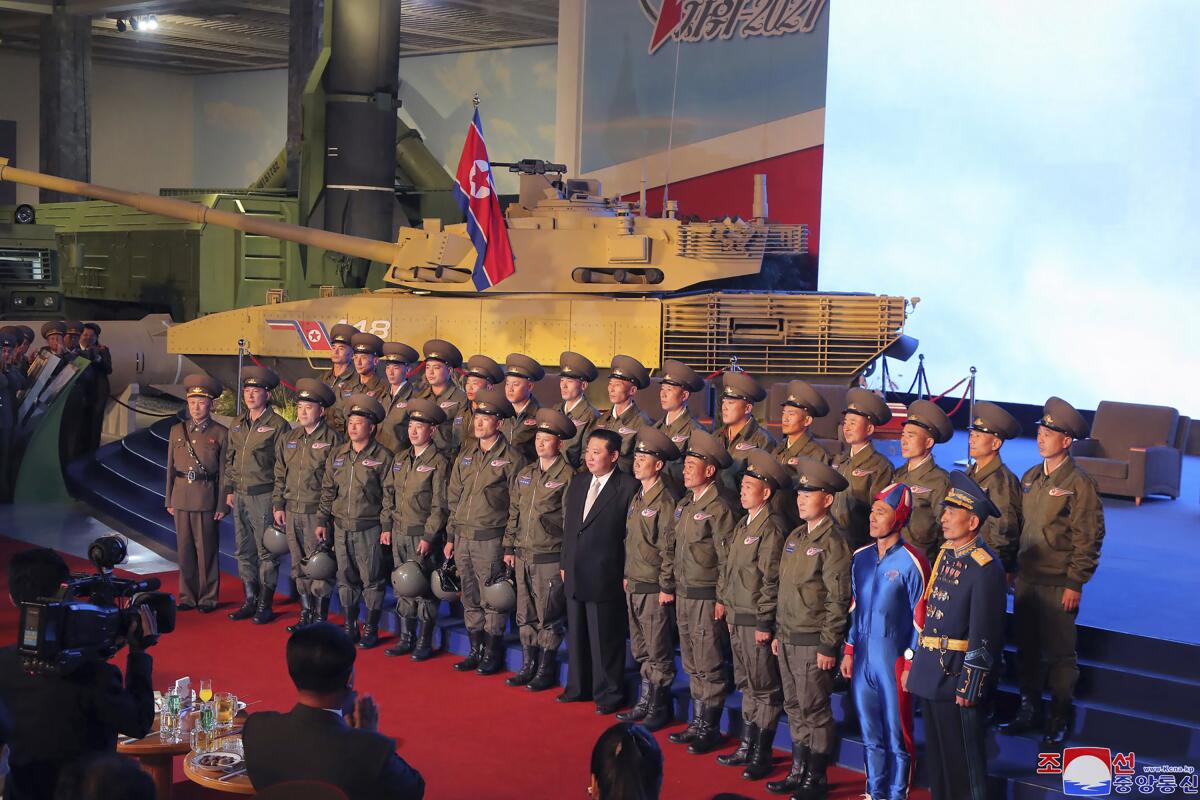 In this photo provided by the North Korean government, North Korean leader Kim Jong Un, center, poses for a group photo with fighter pilots who made the demonstration flight at the opening of an exhibition of weapons systems in Pyongyang, North Korea, Monday, Oct. 11, 2021. Kim reviewed the rare exhibition and vowed to build an “invincible” military, as he accused the United States of creating regional tensions and lacking action to prove it has no hostile intent toward the North, state media reported Tuesday. Independent journalists were not given access to cover the event depicted in this image distributed by the North Korean government. The content of this image is as provided and cannot be independently verified. Korean language watermark on image as provided by source reads: "KCNA" which is the abbreviation for Korean Central News Agency. (Korean Central News Agency/Korea News Service via AP)