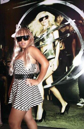 Jowena Miguel, 20, poses for a photo infront of a poster of her idol outside the Nokia Theatre before a sold-out performance.