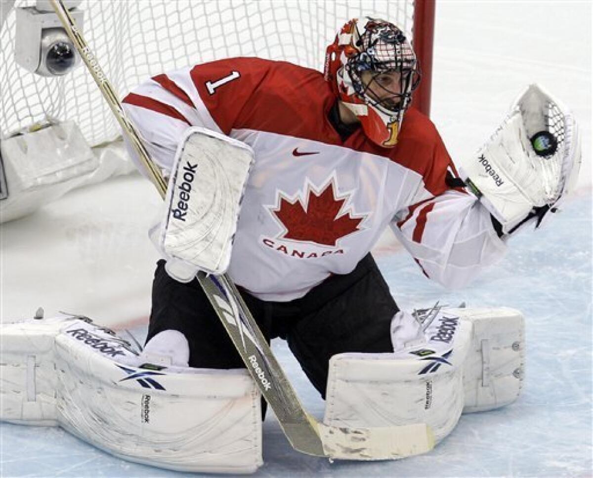 Canada's goaltender Martin Brodeur plays the puck against USA's