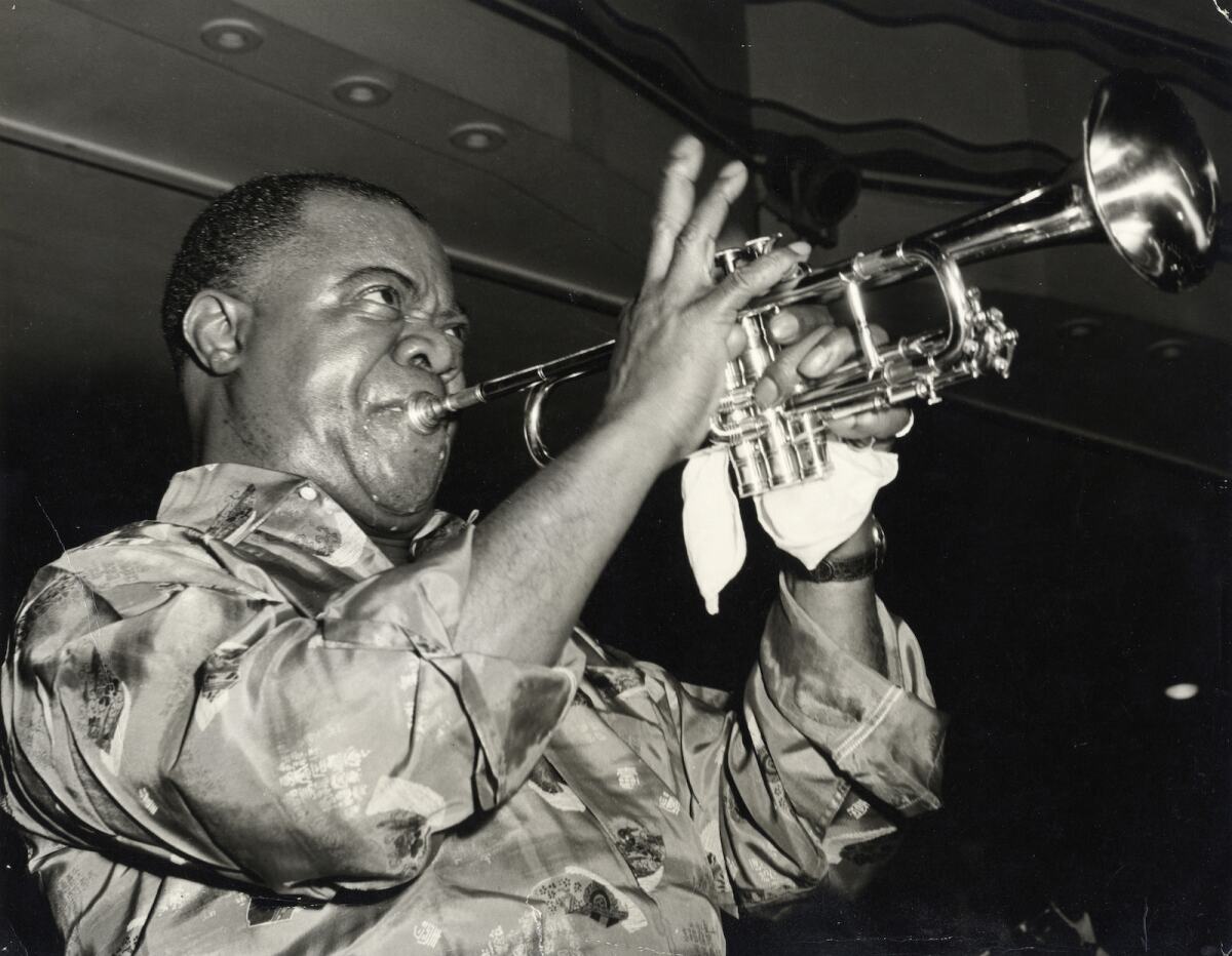 black and white photo of a man playing a trumpet 