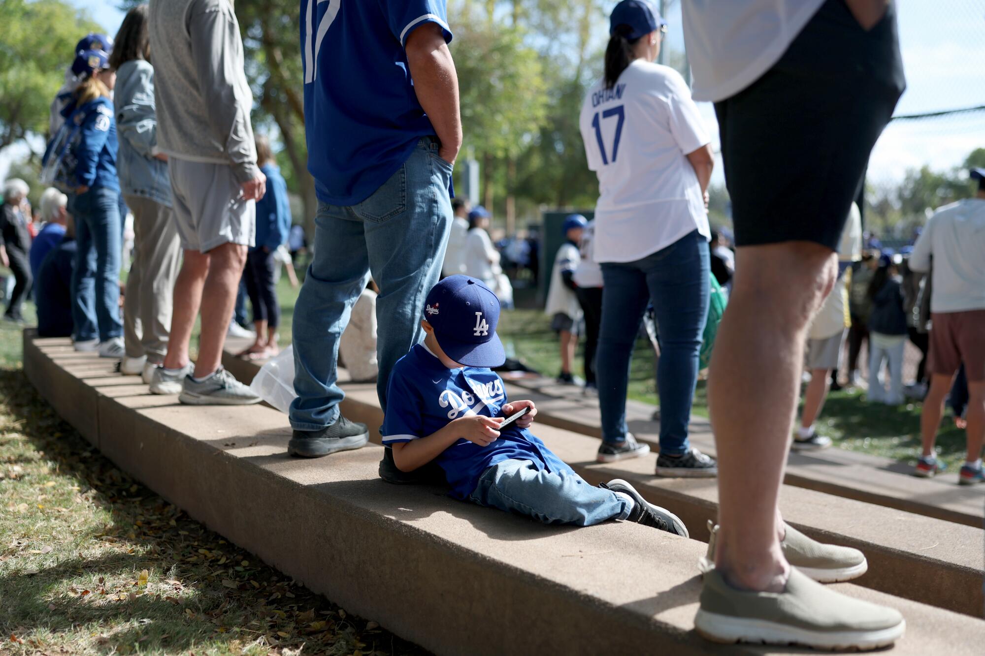 Aden Ramirez, babası Jonny Ramirez'e yaslanırken telefonuyla oynuyor.