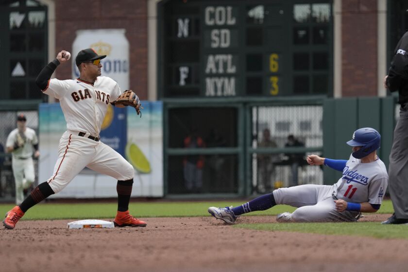 San Francisco Giants second baseman Donovan Solano, left, completes a double play after forcing out Los Angeles Dodgers' AJ Pollock, right, on a ball hit by Albert Pujols during the second inning of a baseball game Thursday, July 29, 2021, in San Francisco. (AP Photo/Tony Avelar)