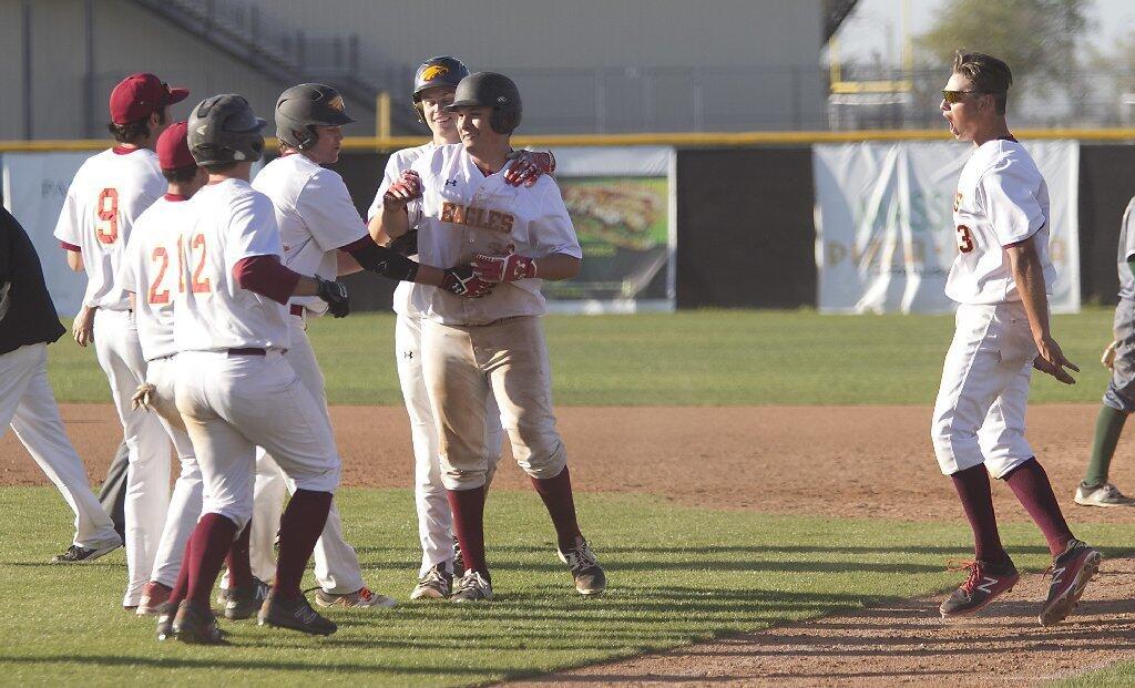 Estancia High's Brian Rodriguez is mobbed by teammates after the Eagles beat Costa Mesa, 2-1, in nine innings.