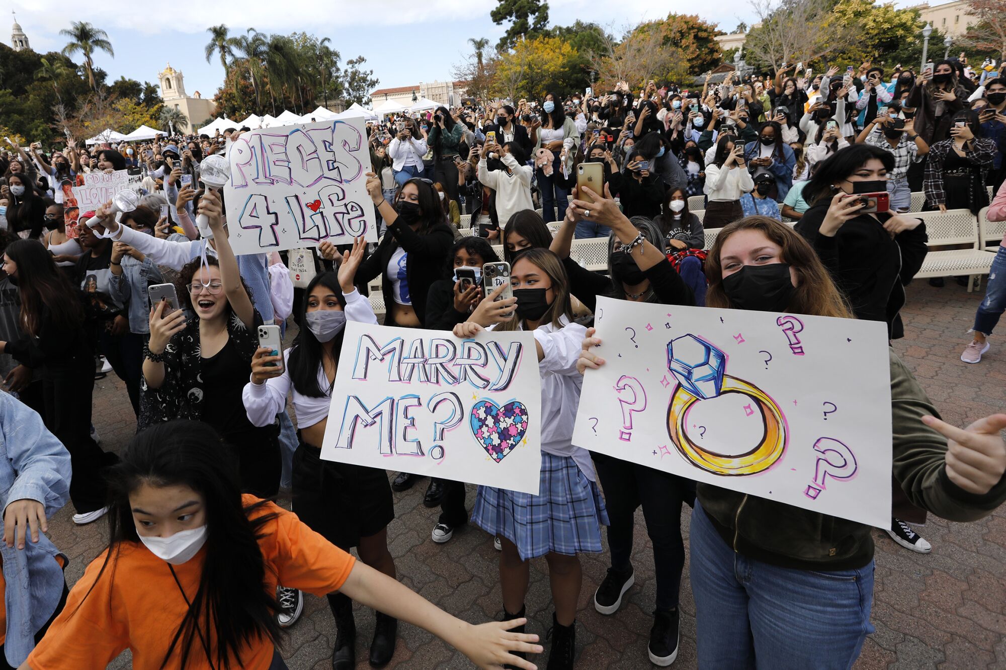 Fans of K-pop with signs of their favorite performers at Korea Day at Balboa Park.