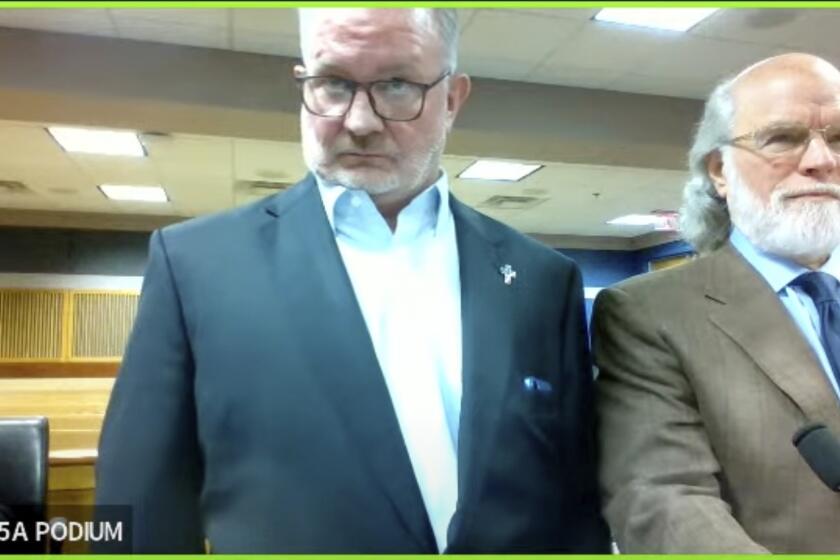In this image made from video from Judge Scott McAfee's virtual Zoom hearing, Scott Graham Hall, left, stands with his attorney Jeffrey S. Weiner, right, in Superior Court of Fulton County before Judge McAfee, not pictured, in Courtroom 5A on Friday, Sept. 29, 2023, in Atlanta. (USA Today via AP, Pool)