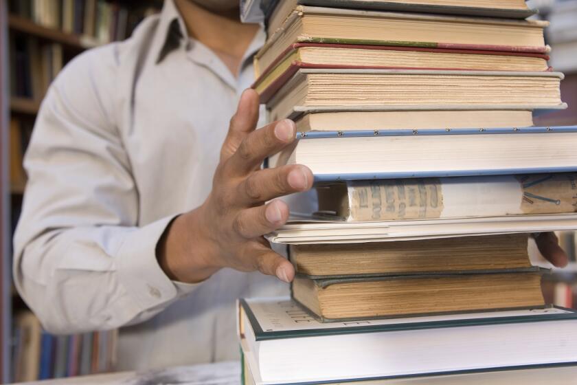 College student with large stack of books ** TCN OUT ** ** TCN OUT ** ORG XMIT: 25FHPIC