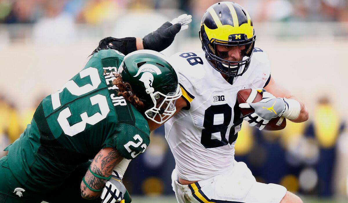 Michigan's Jake Butt, left, looks to get around the tackle of Michigan State's Chris Frey after a third-quarter catch Saturday.